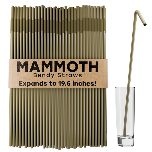 Set of Mammoth gold plastic bendy straws in packaging next to a drinking glass for scale. 